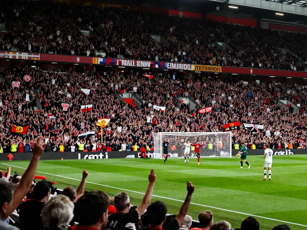 Exciting scene of passionate fans celebrating during the intense match between Manchester United and Liverpool, highlighting the rivalry and statistics of their encounters.